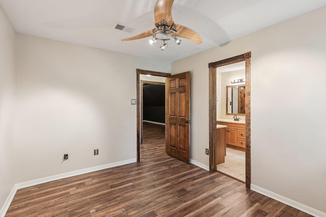5503 Bayou Blvd, Baytown, TX 77521 - unfurnished bedroom with a sink, visible vents, baseboards, and dark wood-style floors