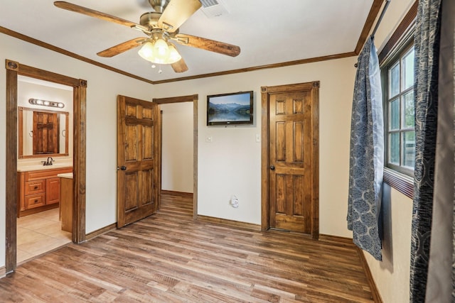 5503 Bayou Blvd, Baytown, TX 77521 - bedroom with baseboards, visible vents, ornamental molding, ensuite bathroom, and light wood-type flooring