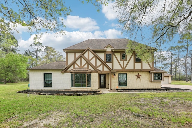 5503 Bayou Blvd, Baytown, TX 77521 - tudor-style house featuring a front lawn, a garage, brick siding, and stucco siding