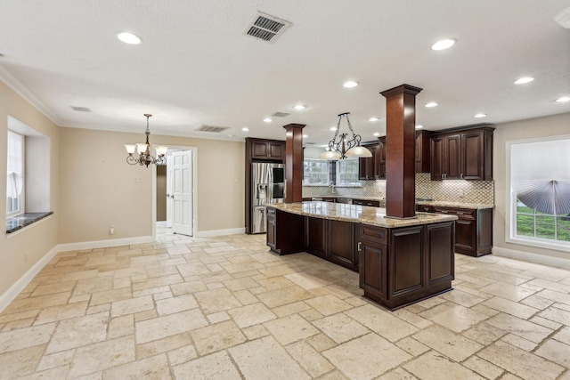 5503 Bayou Blvd, Baytown, TX 77521 - kitchen featuring visible vents, dark brown cabinetry, an inviting chandelier, stainless steel fridge, and ornate columns