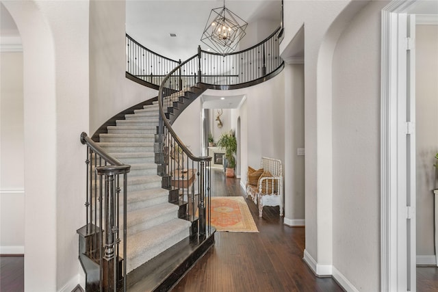 139 Ballantyne Dr, Montgomery, TX 77316 - foyer entrance with stairway, dark wood-style flooring, baseboards, a chandelier, and arched walkways