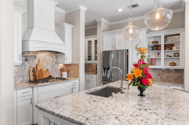 139 Ballantyne Dr, Montgomery, TX 77316 - kitchen with custom range hood, a sink, visible vents, white cabinets, and appliances with stainless steel finishes