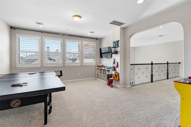 139 Ballantyne Dr, Montgomery, TX 77316 - recreation room featuring carpet floors, arched walkways, a healthy amount of sunlight, and visible vents