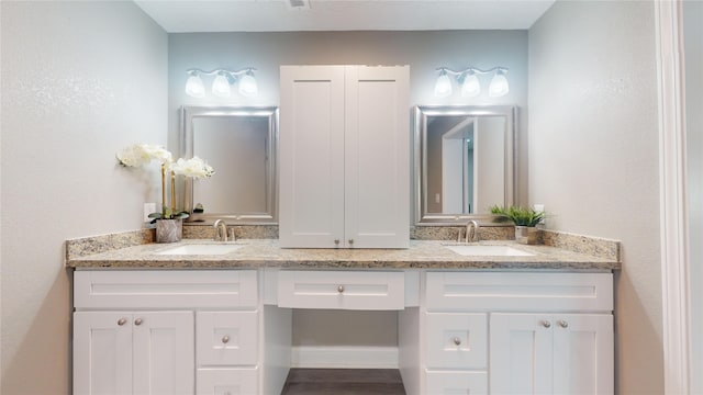 bathroom featuring a sink and double vanity