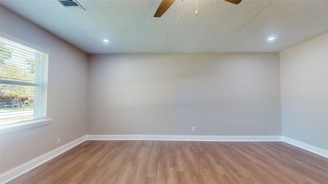 empty room featuring baseboards, visible vents, ceiling fan, and wood finished floors