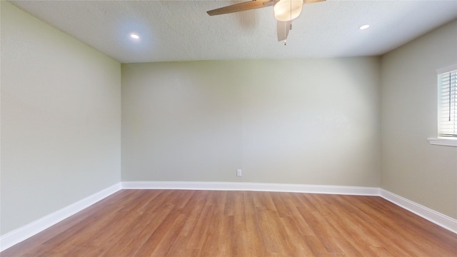 spare room with a textured ceiling, recessed lighting, a ceiling fan, baseboards, and light wood-style floors