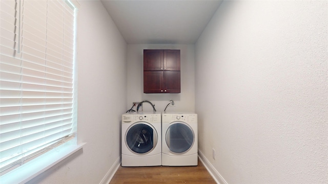 laundry area with baseboards, wood finished floors, and independent washer and dryer