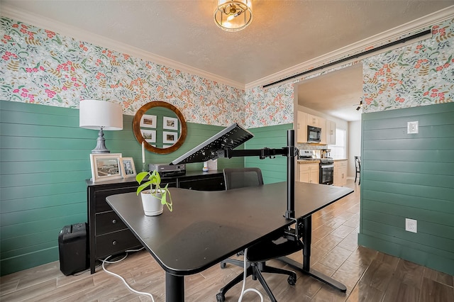 office with ornamental molding, wainscoting, a textured ceiling, wood finished floors, and wallpapered walls