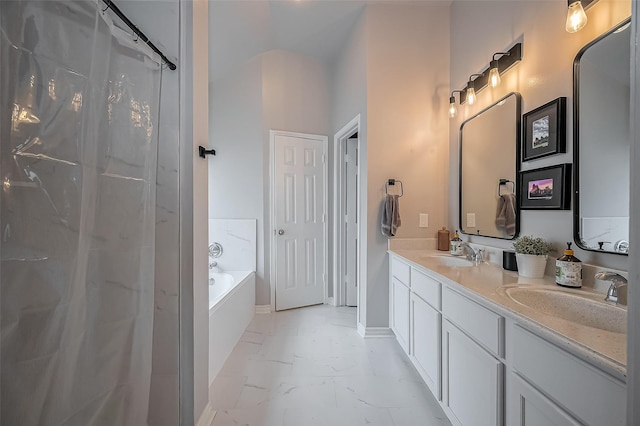 bathroom with a garden tub, marble finish floor, double vanity, and a sink