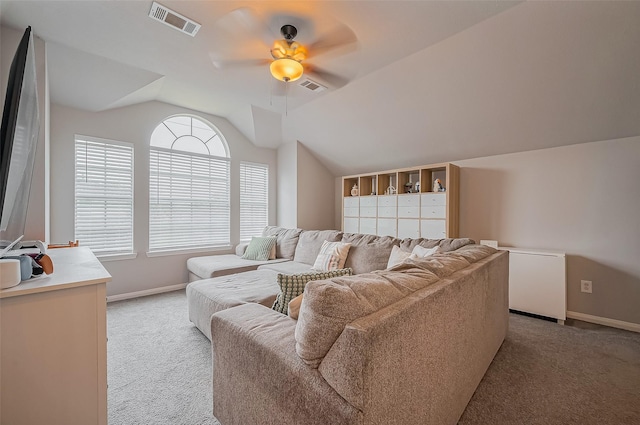 living area with light carpet, visible vents, and vaulted ceiling