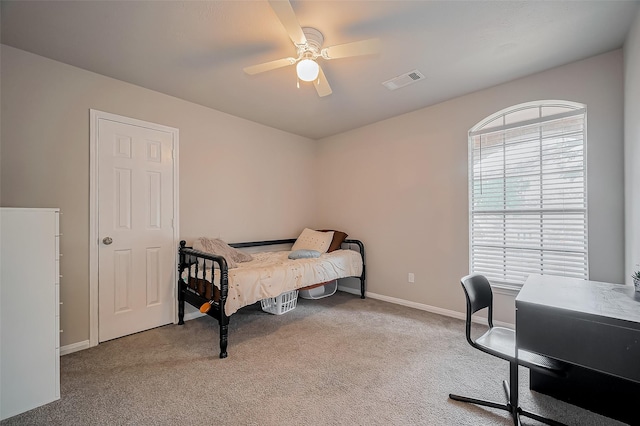 bedroom featuring a ceiling fan, multiple windows, visible vents, and carpet flooring