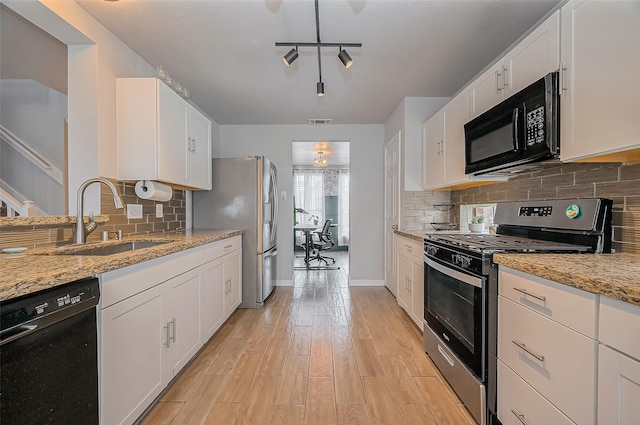 kitchen featuring black appliances, a sink, white cabinets, and light wood-style floors