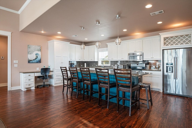 172 Ocean View Dr, Crystal Beach, TX 77650 - kitchen featuring appliances with stainless steel finishes, dark wood-style flooring, a breakfast bar, dark countertops, and decorative backsplash