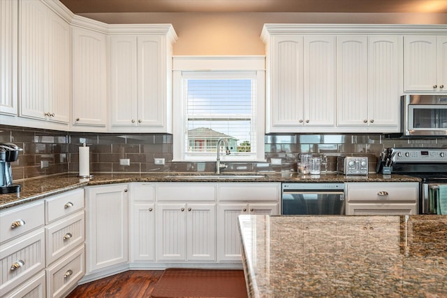 172 Ocean View Dr, Crystal Beach, TX 77650 - kitchen with appliances with stainless steel finishes, tasteful backsplash, white cabinets, and dark stone counters