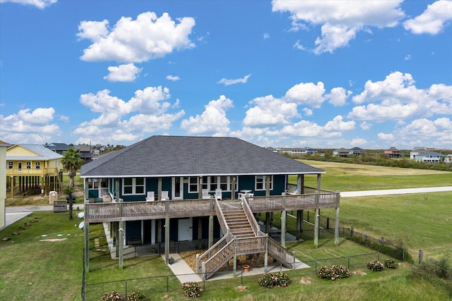 back of house featuring a patio, a fenced backyard, roof with shingles, stairs, and a yard