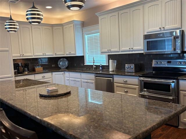 172 Ocean View Dr, Crystal Beach, TX 77650 - kitchen with appliances with stainless steel finishes, dark stone counters, backsplash, a kitchen breakfast bar, and recessed lighting