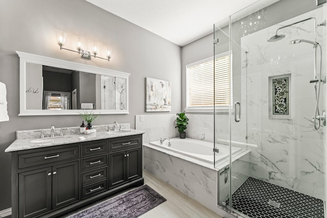 full bath featuring a sink, a marble finish shower, a garden tub, and double vanity