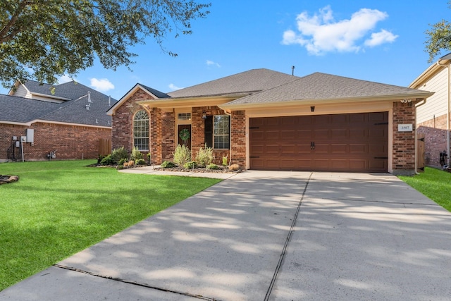 ranch-style house with a front lawn, concrete driveway, an attached garage, a shingled roof, and brick siding