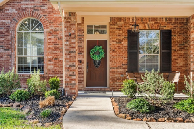 entrance to property featuring brick siding and a porch