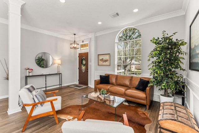 living room with visible vents, crown molding, ornate columns, and wood finished floors