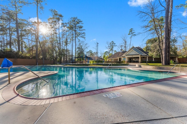 community pool with fence and a patio area