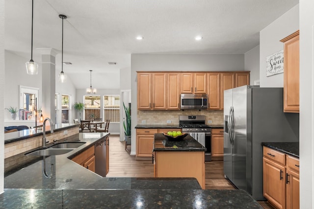 kitchen featuring a center island, stainless steel appliances, tasteful backsplash, and a sink