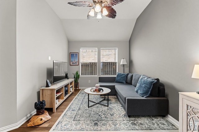 living area featuring baseboards, wood finished floors, a ceiling fan, and vaulted ceiling