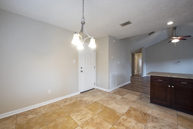 unfurnished dining area with visible vents, baseboards, a textured ceiling, and vaulted ceiling