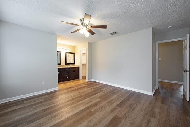 empty room with visible vents, baseboards, wood finished floors, and a ceiling fan