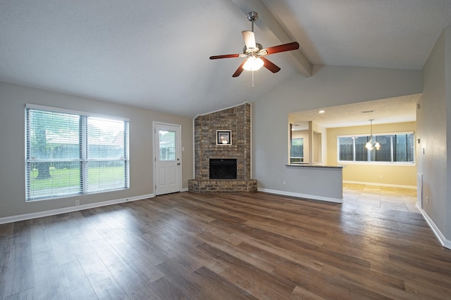 unfurnished living room with a ceiling fan, wood finished floors, a fireplace, baseboards, and vaulted ceiling with beams