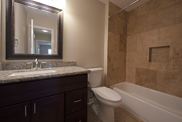 bathroom with vanity, toilet, a textured wall, and shower / bath combination