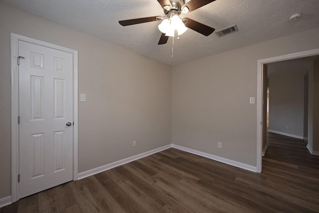 empty room with visible vents, baseboards, dark wood finished floors, a textured ceiling, and a ceiling fan