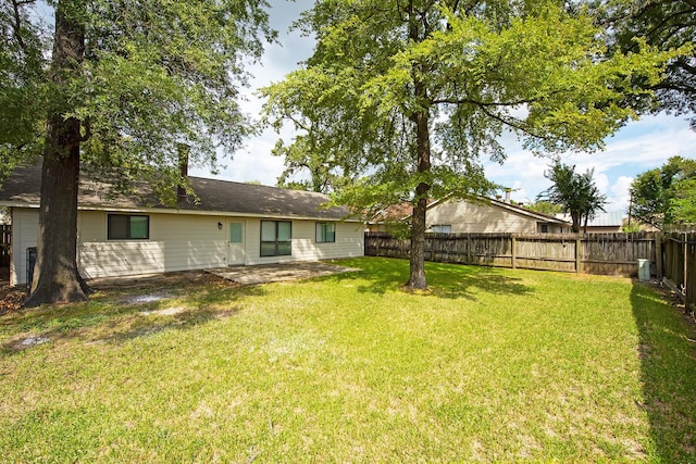 rear view of property with a patio, a fenced backyard, and a lawn