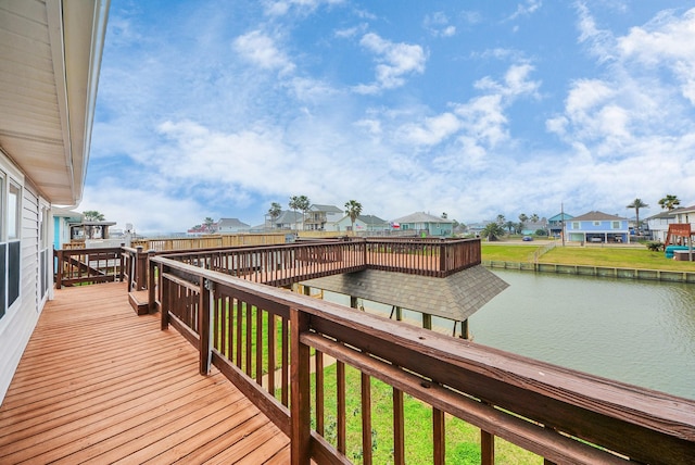 wooden terrace with a yard, a water view, and a residential view