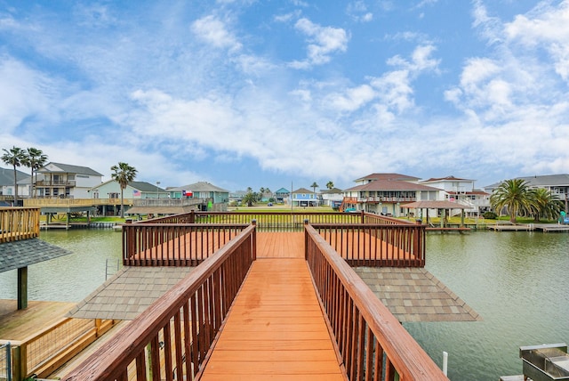 view of dock with a residential view and a water view