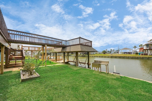 view of dock with a lawn and a water view