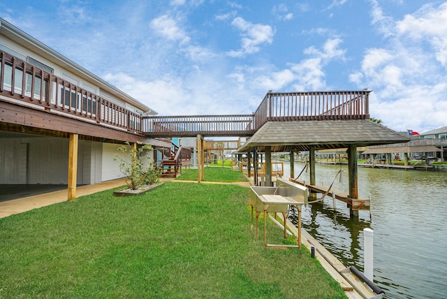 dock area featuring a water view, a lawn, and boat lift