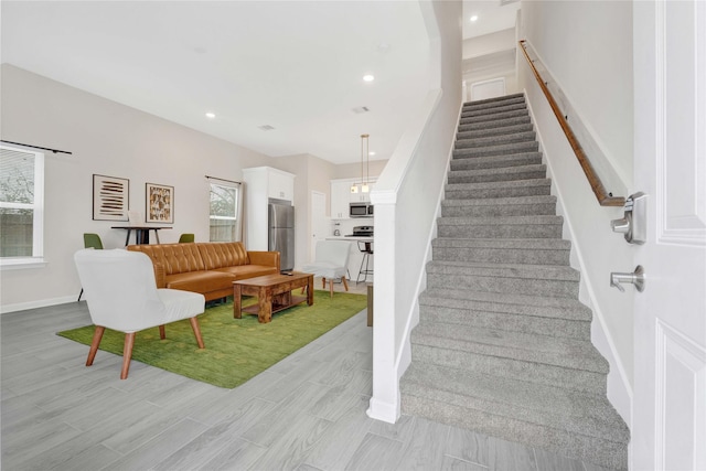 stairway with recessed lighting, baseboards, and wood finished floors