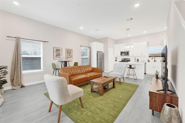 living area featuring baseboards, visible vents, and recessed lighting