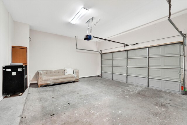 garage featuring a garage door opener and baseboards