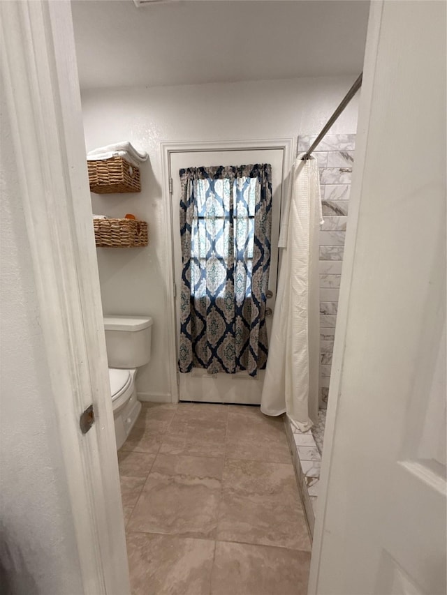 full bath featuring toilet and a shower with shower curtain