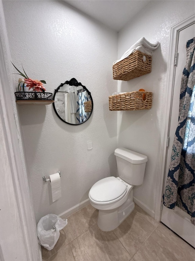 full bathroom with toilet, baseboards, a shower with shower curtain, and tile patterned floors