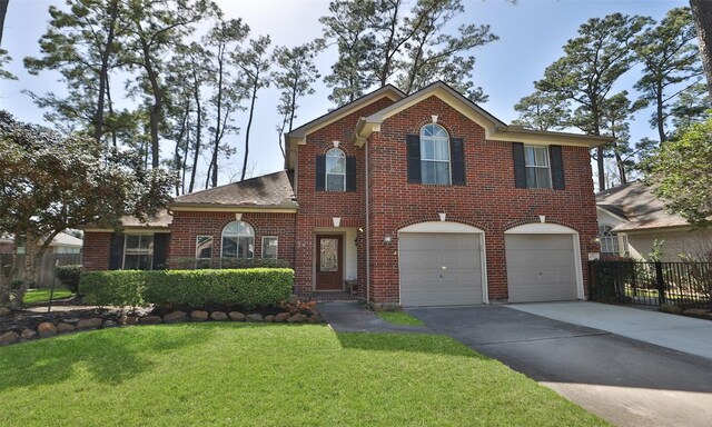 traditional-style house featuring brick siding, fence, a garage, driveway, and a front yard