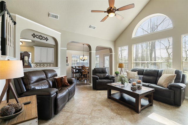 living room featuring high vaulted ceiling, visible vents, arched walkways, and ceiling fan with notable chandelier