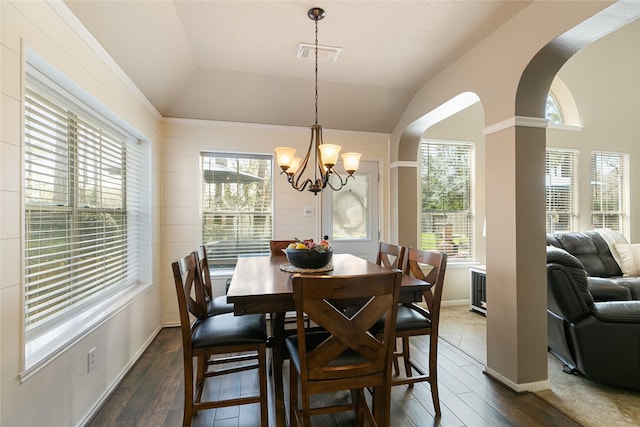 dining area with arched walkways, lofted ceiling, visible vents, an inviting chandelier, and dark wood-type flooring