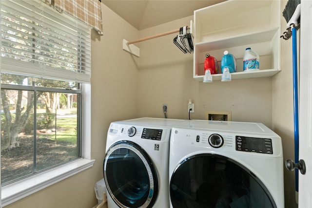 clothes washing area featuring washing machine and clothes dryer and laundry area