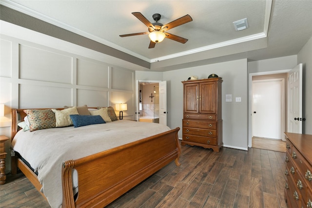 bedroom with dark wood-style floors, visible vents, a raised ceiling, and ceiling fan