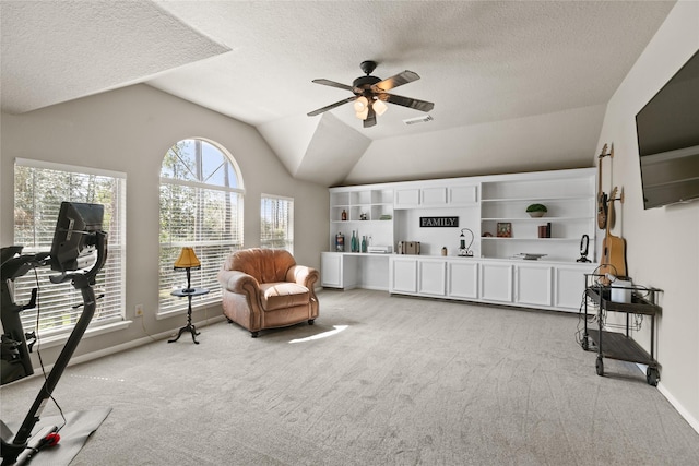 living area with a ceiling fan, visible vents, light carpet, a textured ceiling, and lofted ceiling