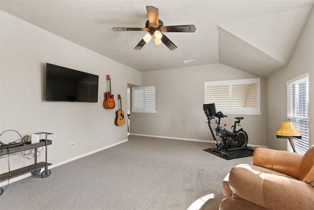 carpeted living area with ceiling fan, visible vents, baseboards, and vaulted ceiling