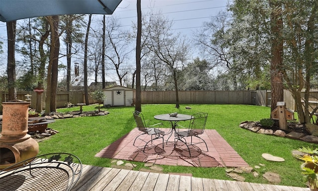 view of yard with a storage shed, a patio area, an outdoor structure, and a fenced backyard